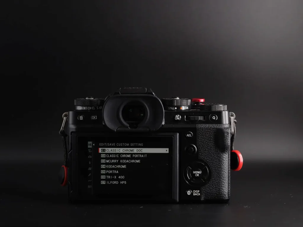 The rear of the Fujifilm X-T5 camera shot on a black background and showing the rear D-pad and other controls. 