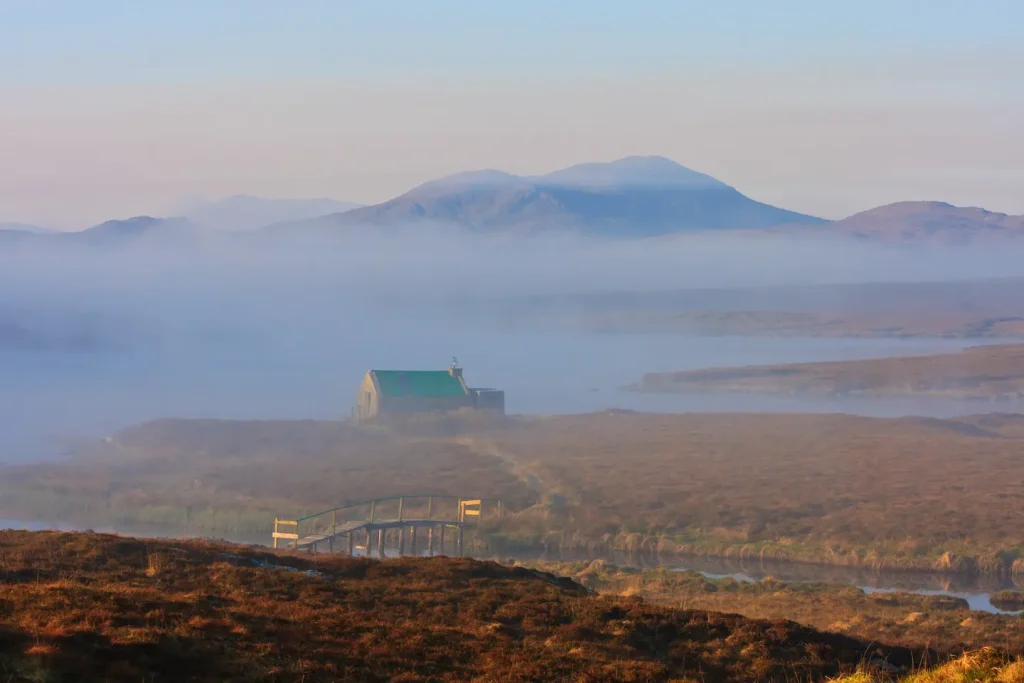A Scottish bothy on the Isle of Lewis, draped in morning mist and warm tones.