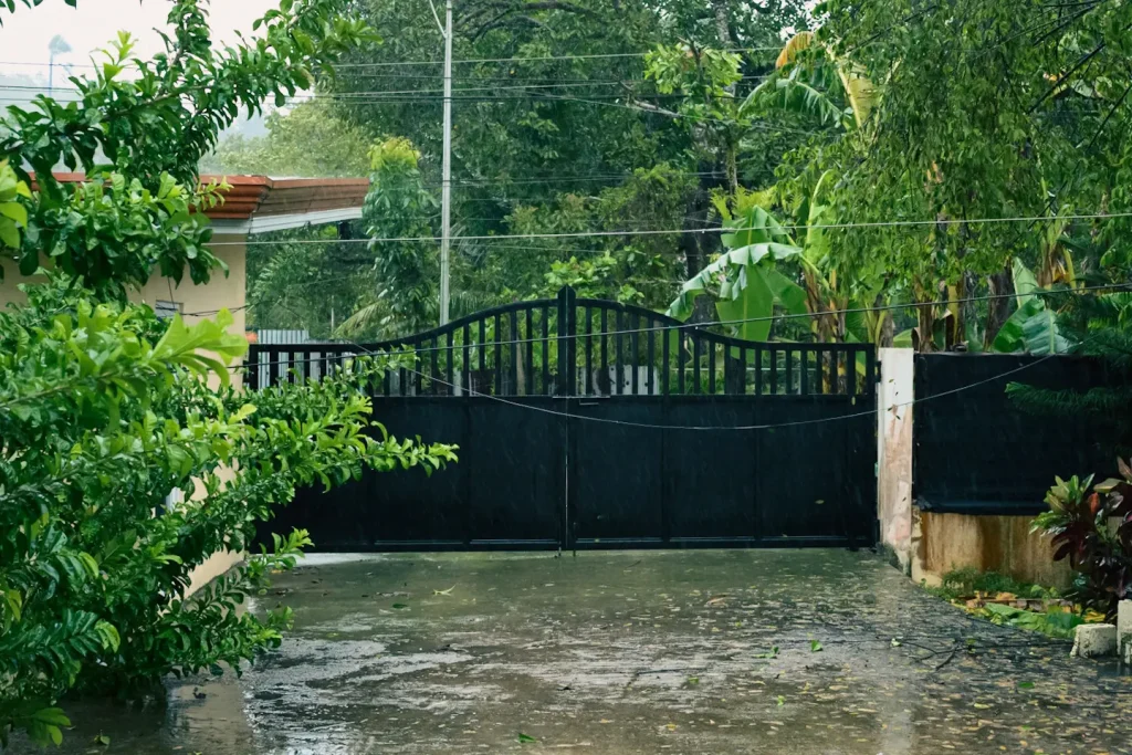 The view of a houses gate and driveway in driving rain caused by the aftermath of typhoon Tino in the Philippines. Photo taken on the Nikon Z6III camera. 