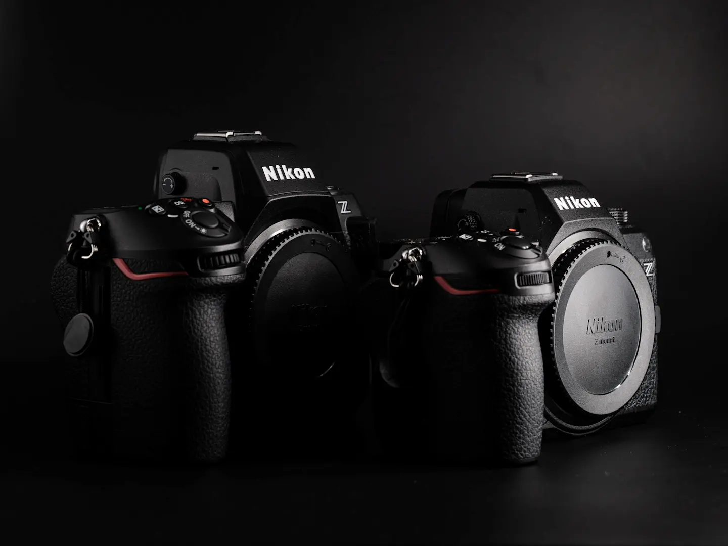 Nikon Z8 camera next to the Nikon Z6III. Photographed on black background in dramatic light.
