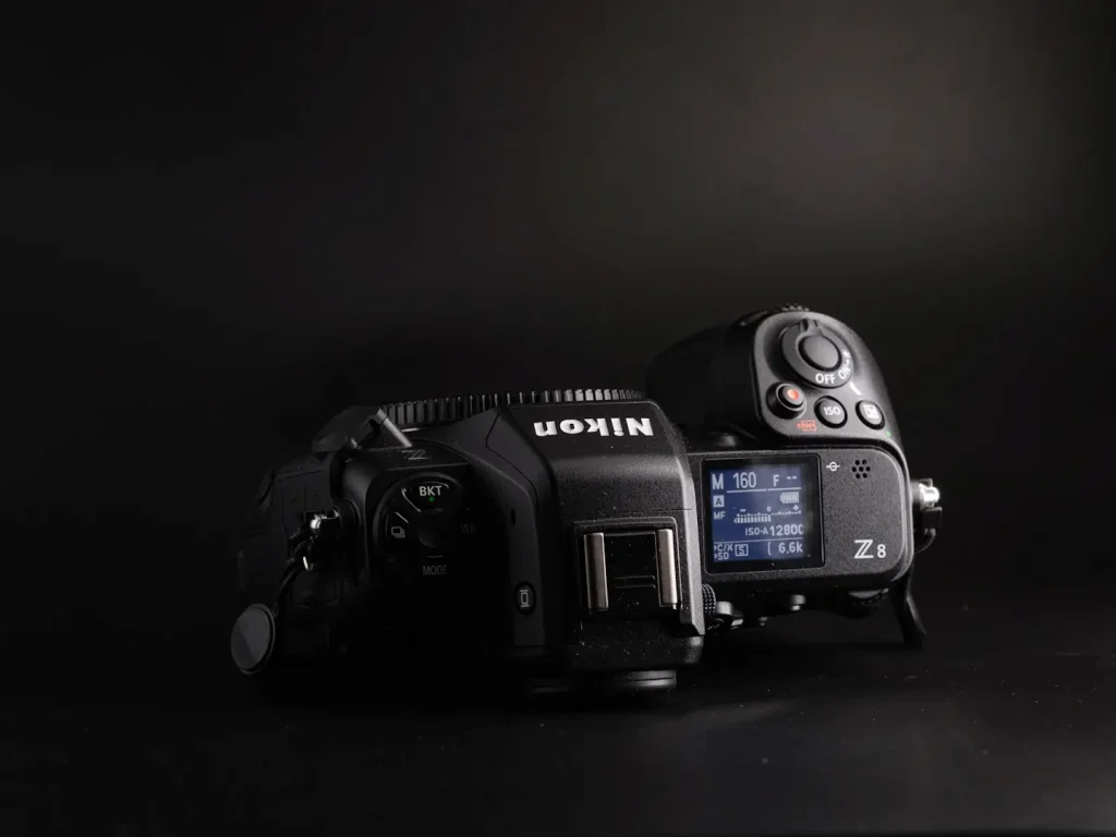 The top view of the Nikon Z8 camera, showing its top LCD screen and button layout. Photo is taken on a black background. 