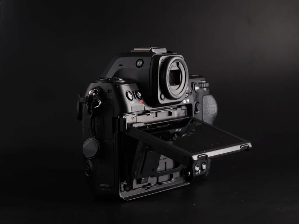 The three-way tilting rear LCD screen of the Nikon Z8 in its extended position. Photo is taken on a black background with dramatic lighting. 