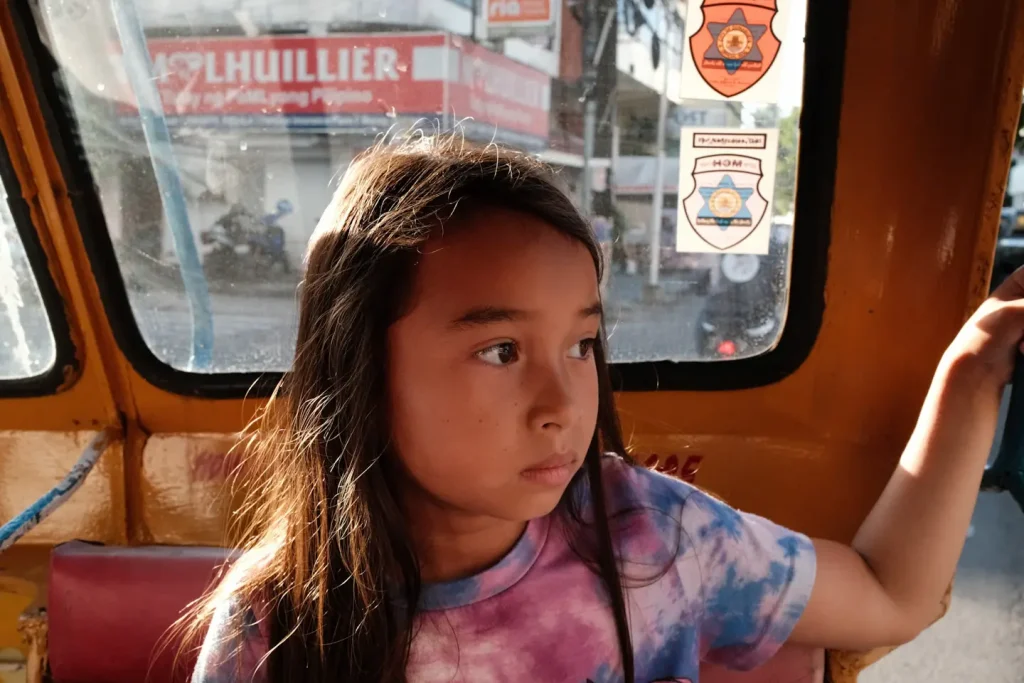 A girl sitting in a trike looking out in the Philippines.