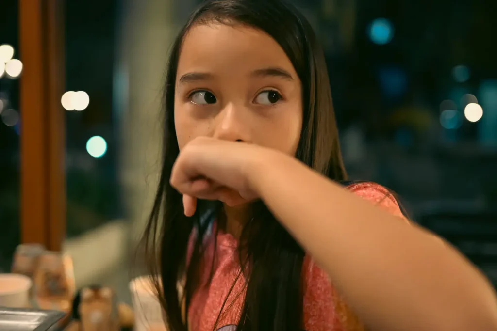A young girl photographed indoors at a restaurant at night. Photo taken on the Nikon Zf camera. 