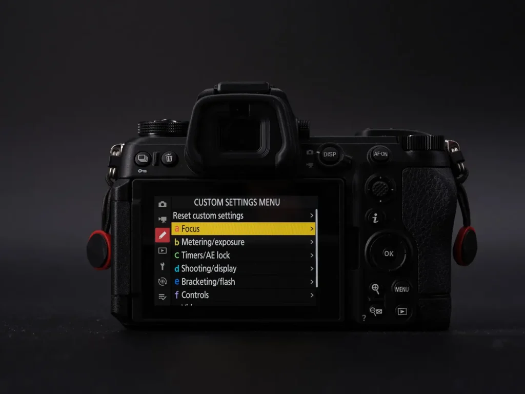 The rear screen of the Nikon Z6III camera showing the Focus menu options. Photo is taken on a black background in dramatic light. 