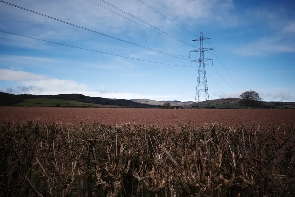An electricity pylon in the middle of farmland in Perthshire, Scotland. 