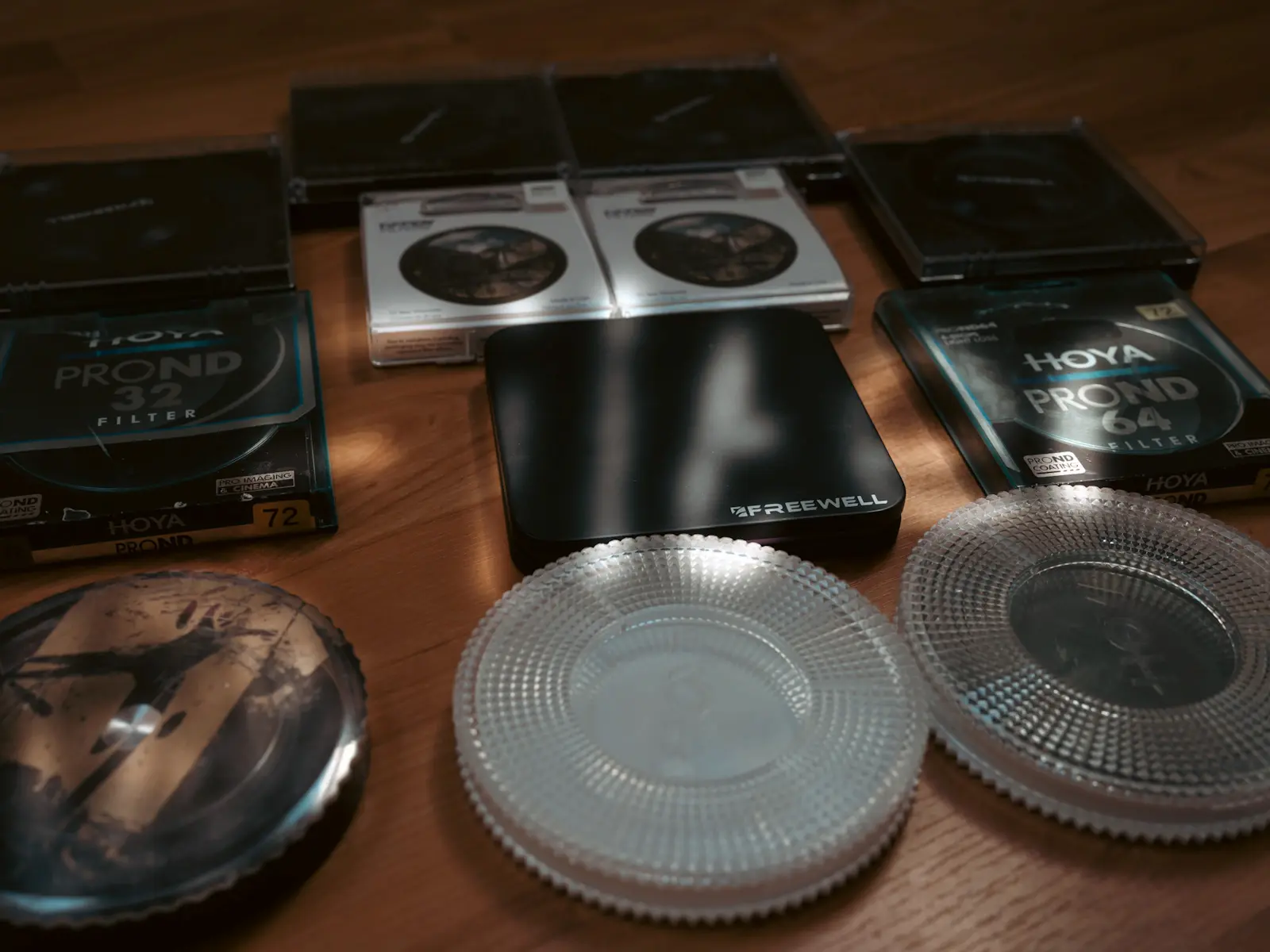 A selection of photography filters displayed on a wooden floor with filtration effects added to the photo.