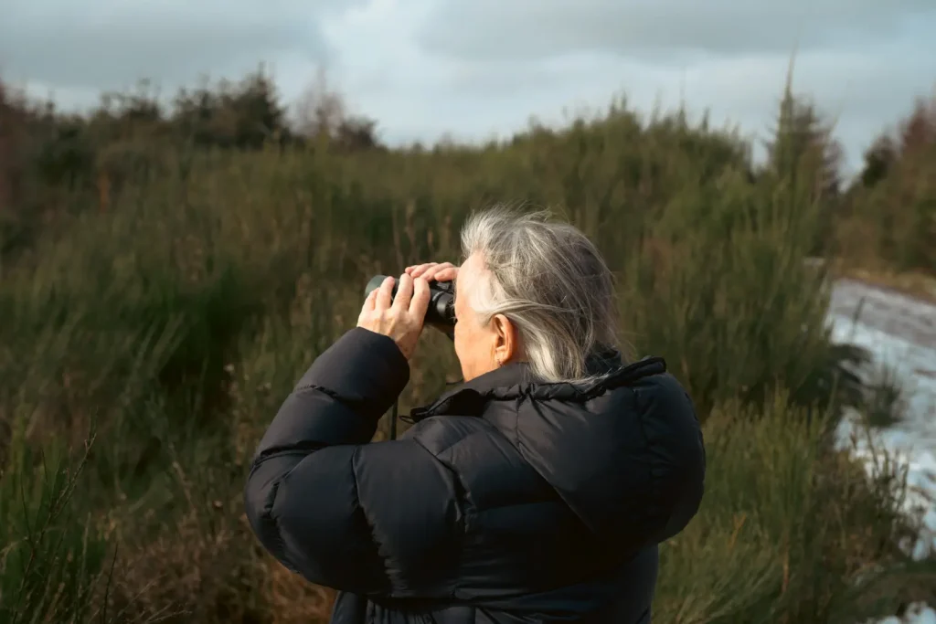 An older lady standing on the Knock of crieff, looking at the wildlife through binoculars. Photo is taken on the Nikon Z8 camera and 24-120mm f/4S lens. 