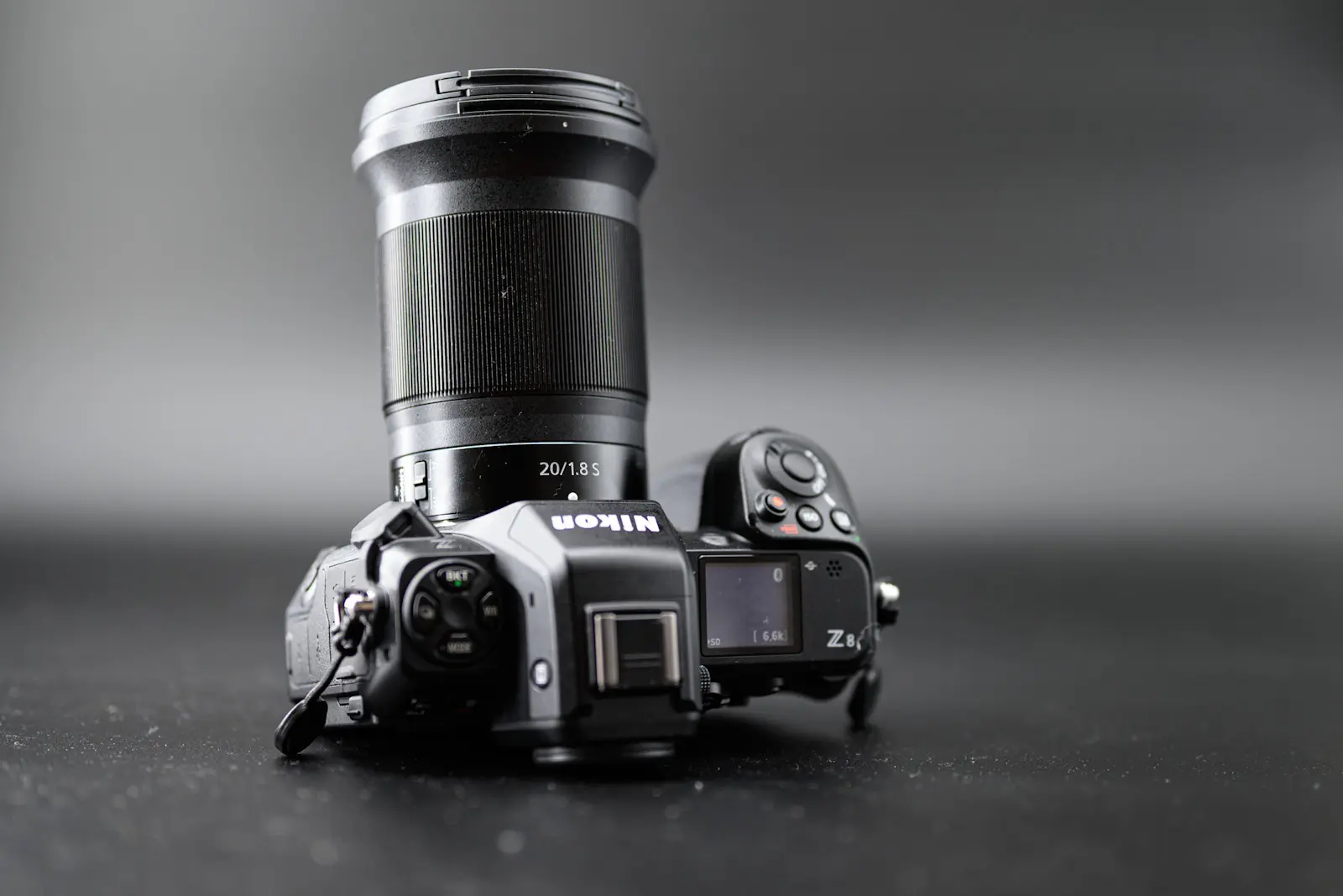 The Nikon Z 20mm 1.8S lens attached to the Nikon Z8 camera. Photograph is taken on a black background.
