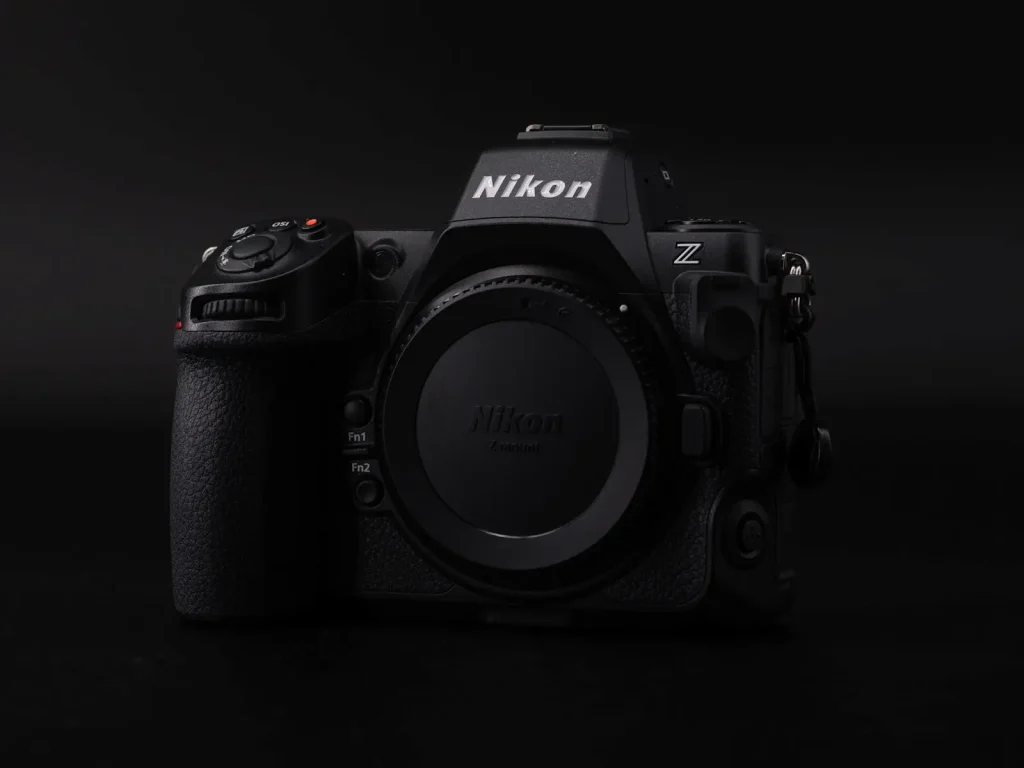 The Nikon Z8 camera photographed in dramatic dark light against a black background. The photo shows the front of the camera. 