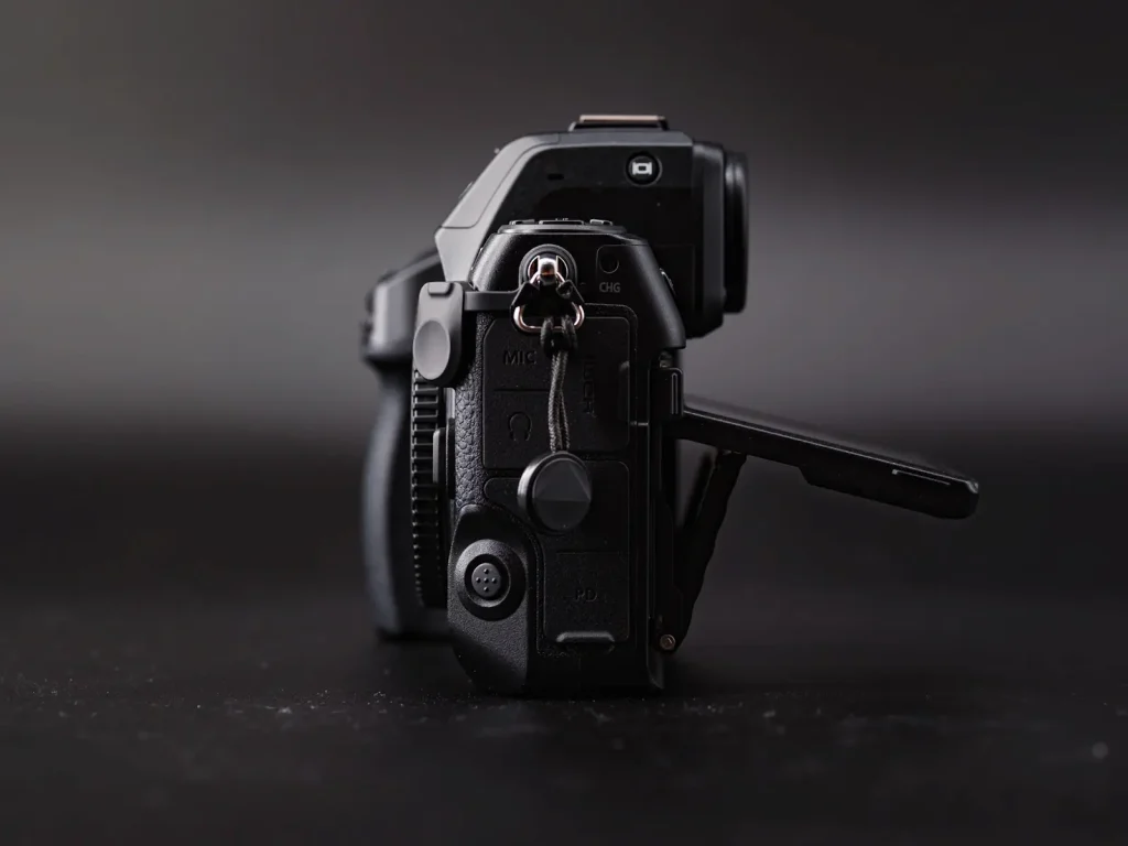 The rear screen of the Nikon Z8 in its open position as viewed from the side. Photo is taken on a black background. 