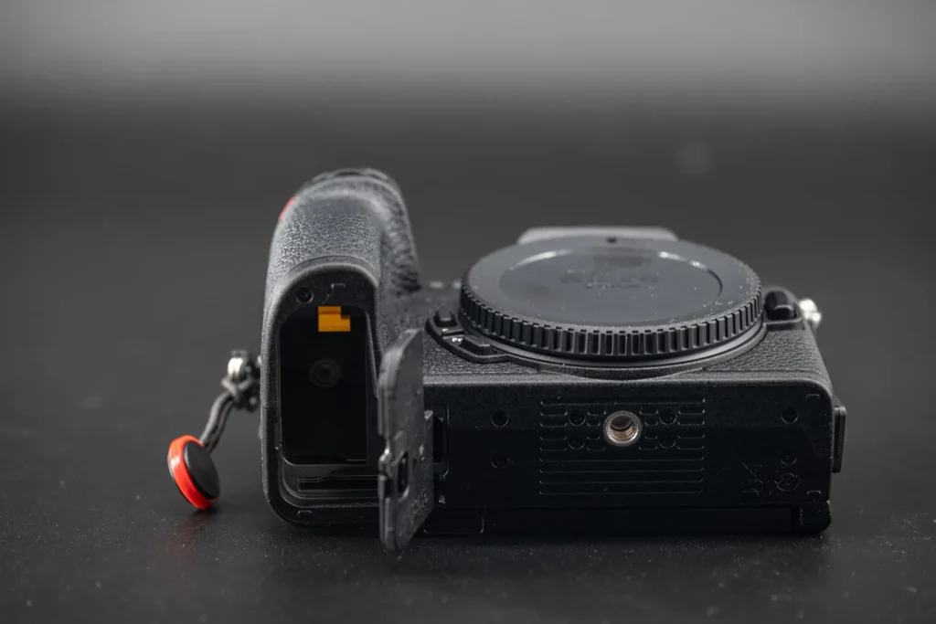 The base of the Nikon Z50II camera with battery compartment door open.