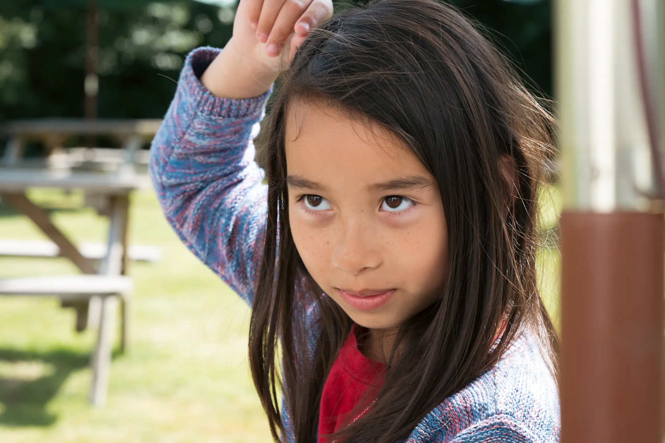 A photo of my daughter, sat at a picnic table in a beer garden. Taken on the Nikon Z6III and Nikon Z 85mm 1.8S lens.