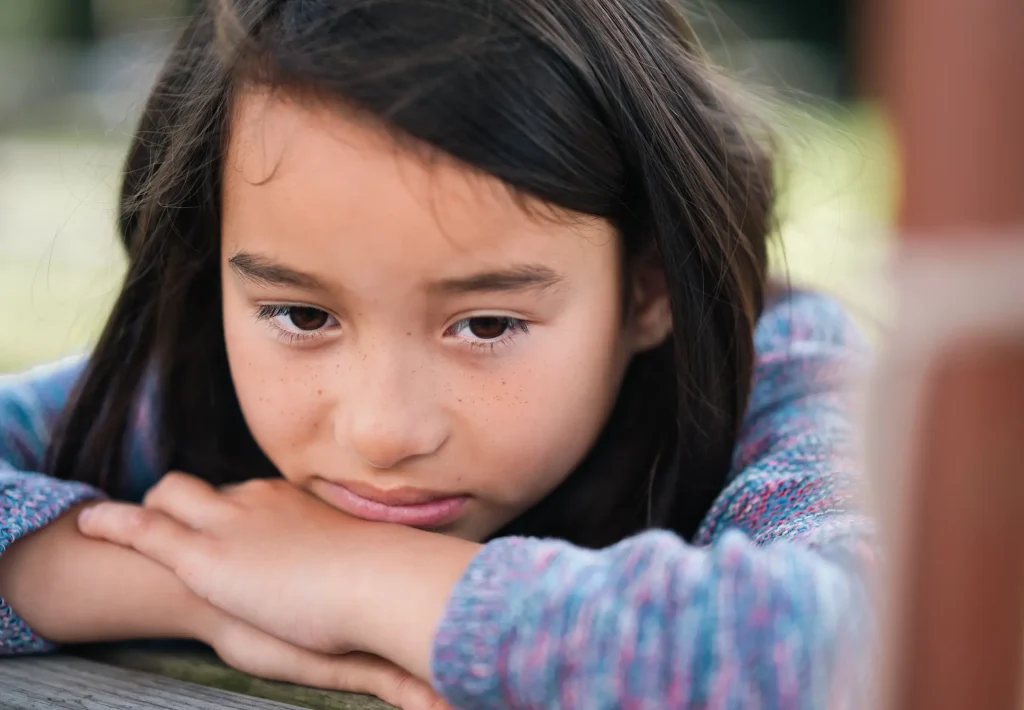 My daughter Sofia who is 9 years old, waiting for food at a pub table resting her head on her hands. Shot on the Nikon Z6III and Nikon Z 85mm 1.8S lens at an aperture of f/1.8. 