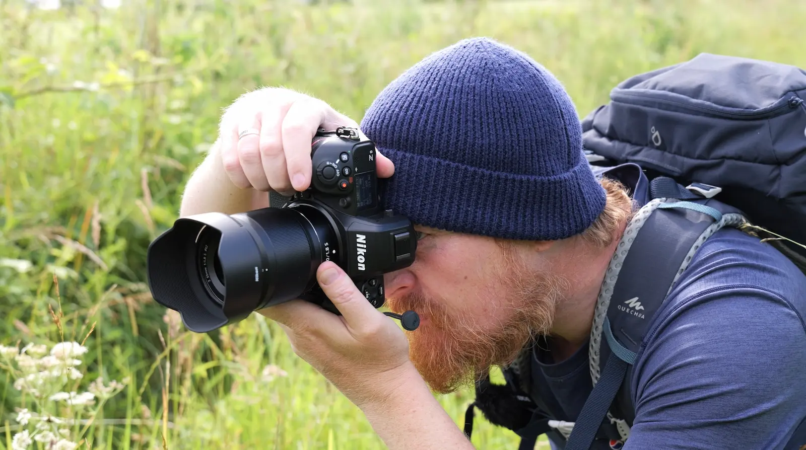 A photographer crouches down to take a photo with the Nikon Z8 camera and Nikon Z 50mm 1.8S lens.