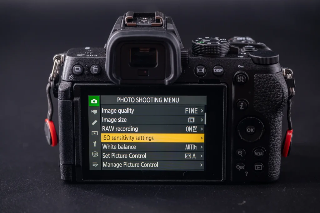 The rear of the Nikon Z50II with the Photo shooting menu showing the ISO sensitivity settings option highlighted.