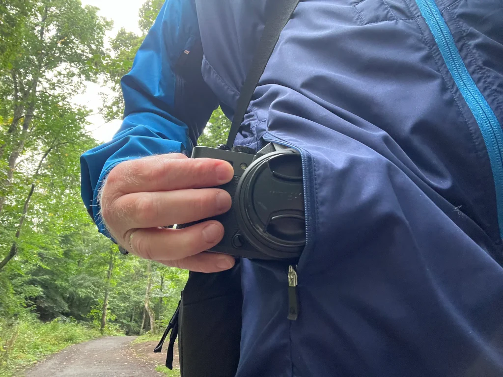 The Fuji X-T30 III camera being slipped in to a jacket pocket. 